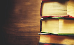 stack of books on the dark wood background. toning. selective focus on the middle book